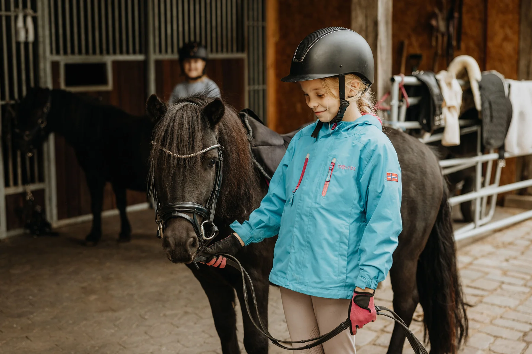 Kinder mit den Ponys auf dem Hof