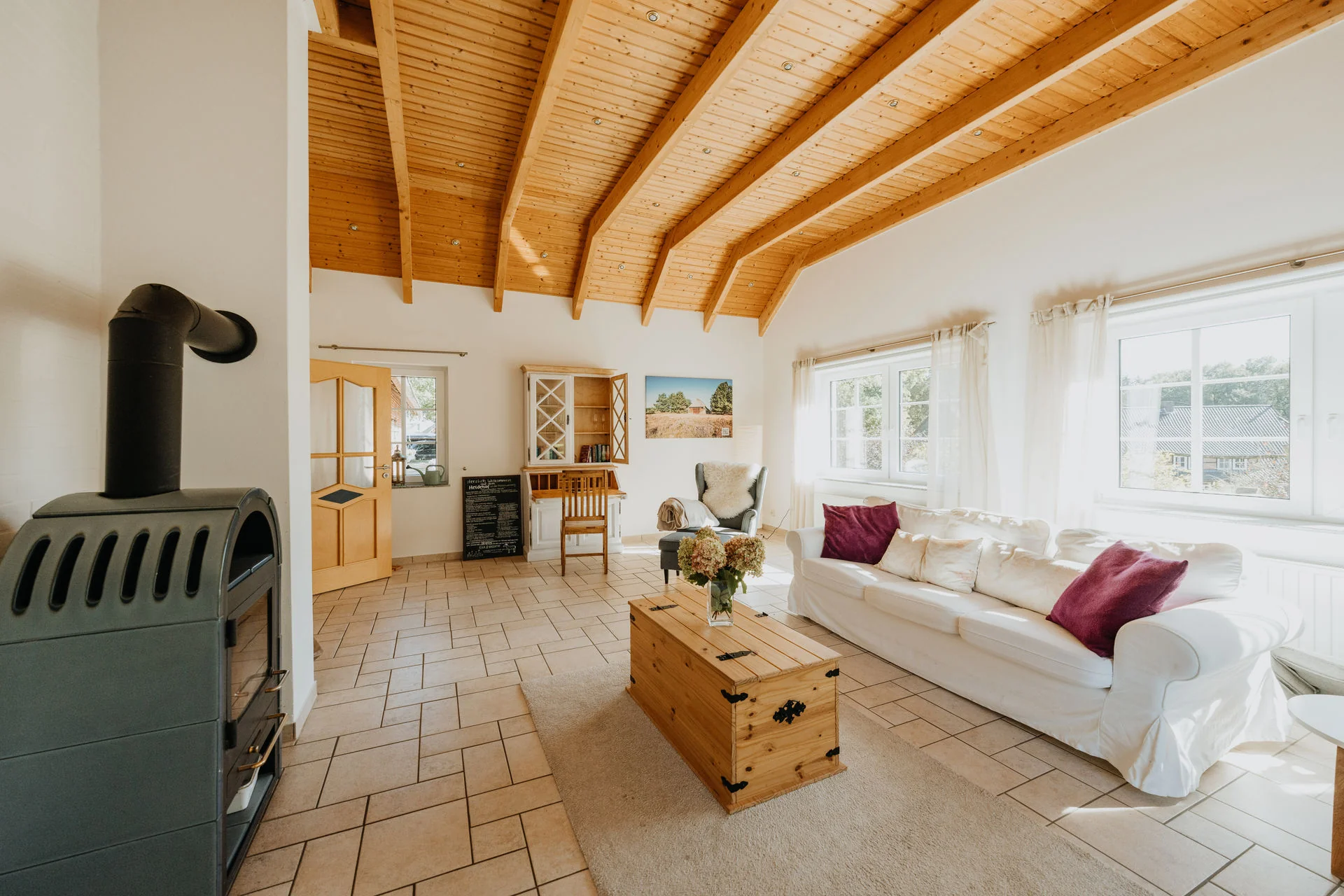 Haverbecker Heide: Wohnzimmer mit Kamin, hellem Sofa und großen Fenstern