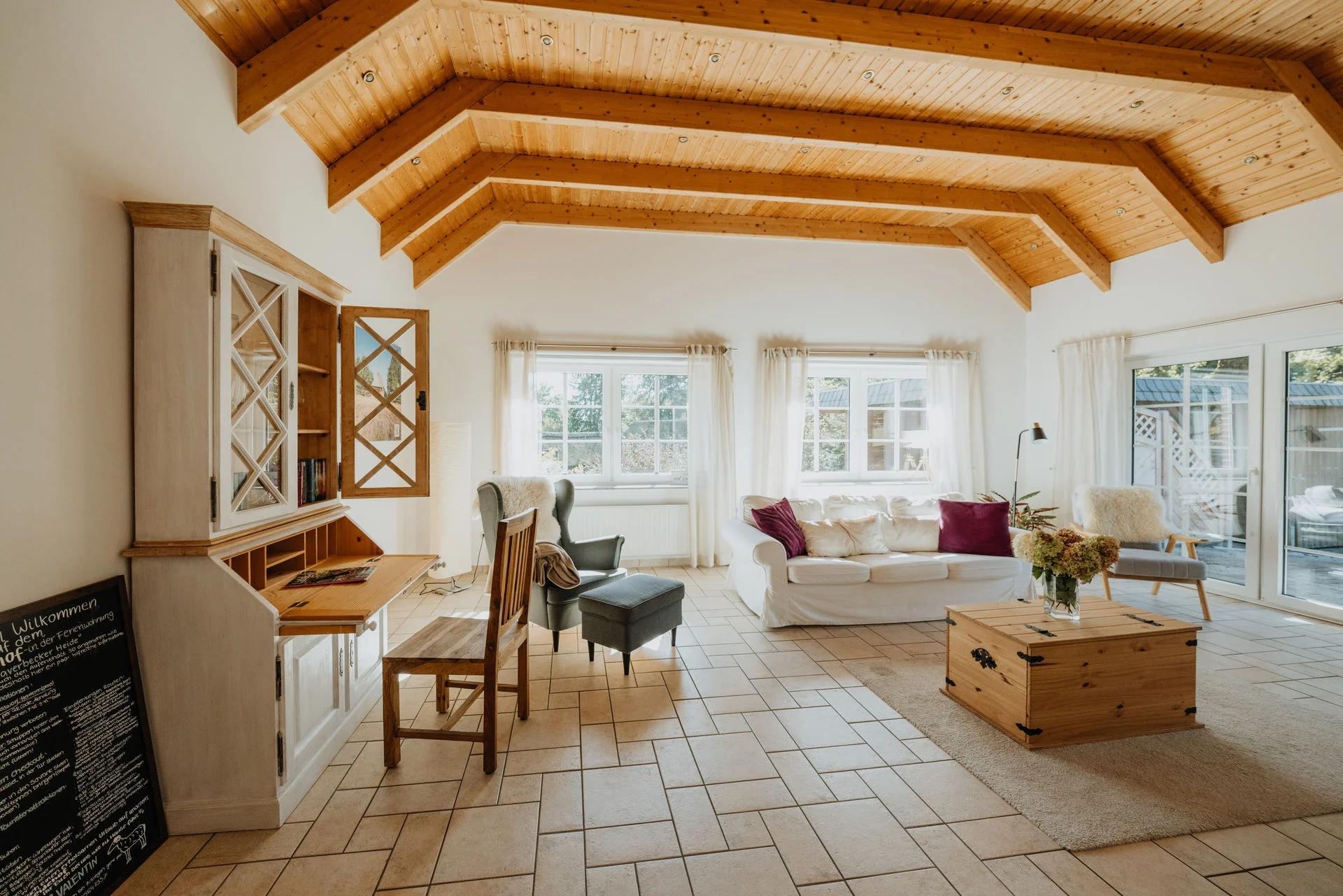 Haverbecker Heide: Wohnzimmer mit Sekretär und Sitzbereich unter der Holzdecke