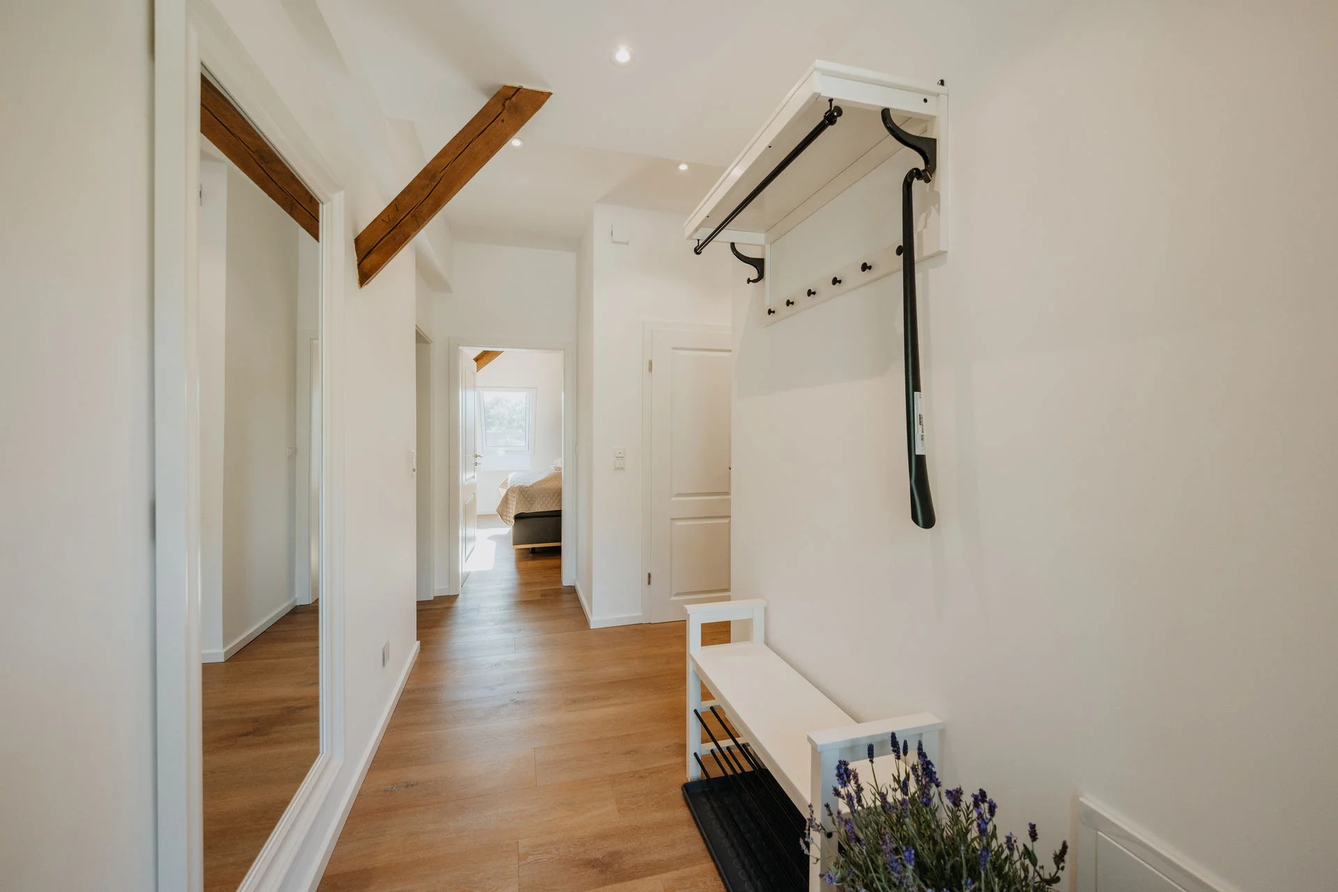 HeidePanorama: Flur mit Garderobe, Sitzbank und sichtbaren Holzbalken