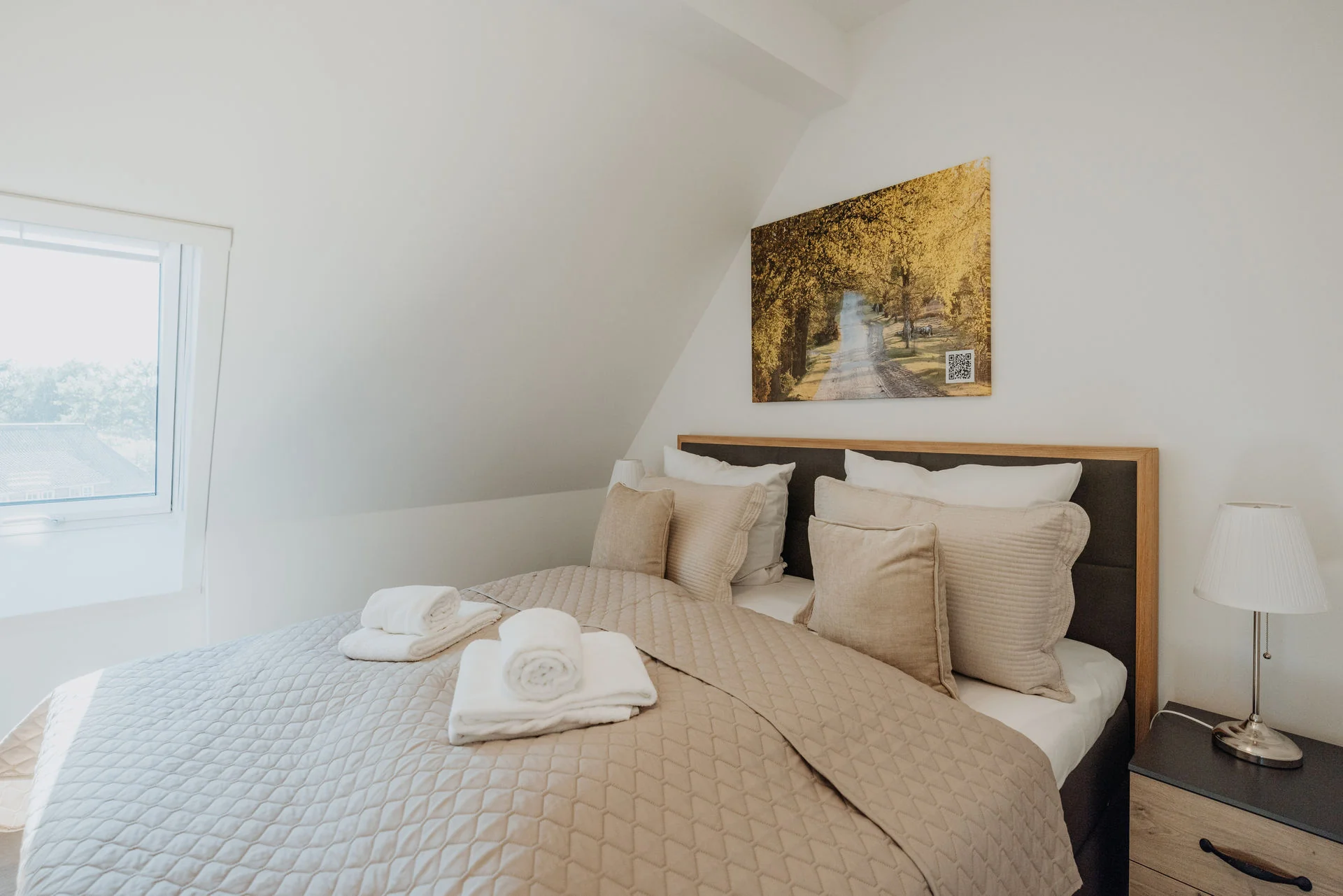 HeidePanorama: Doppelbett mit gefalteten Handtüchern neben dem Fenster