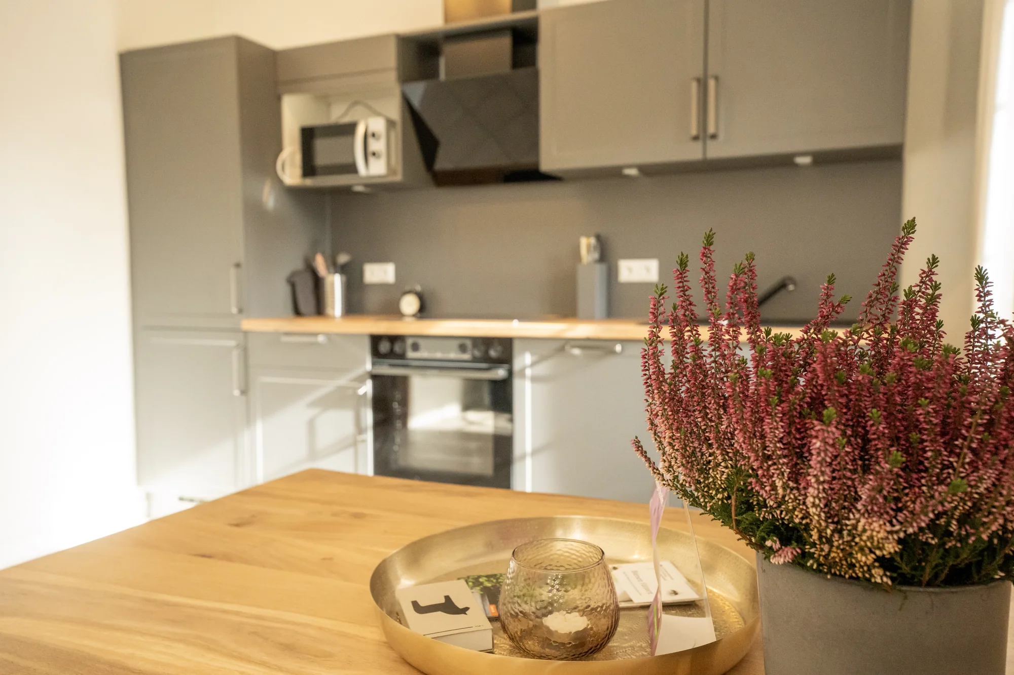 Heidetraum: Esstisch mit Blumenschmuck vor der Küchenzeile