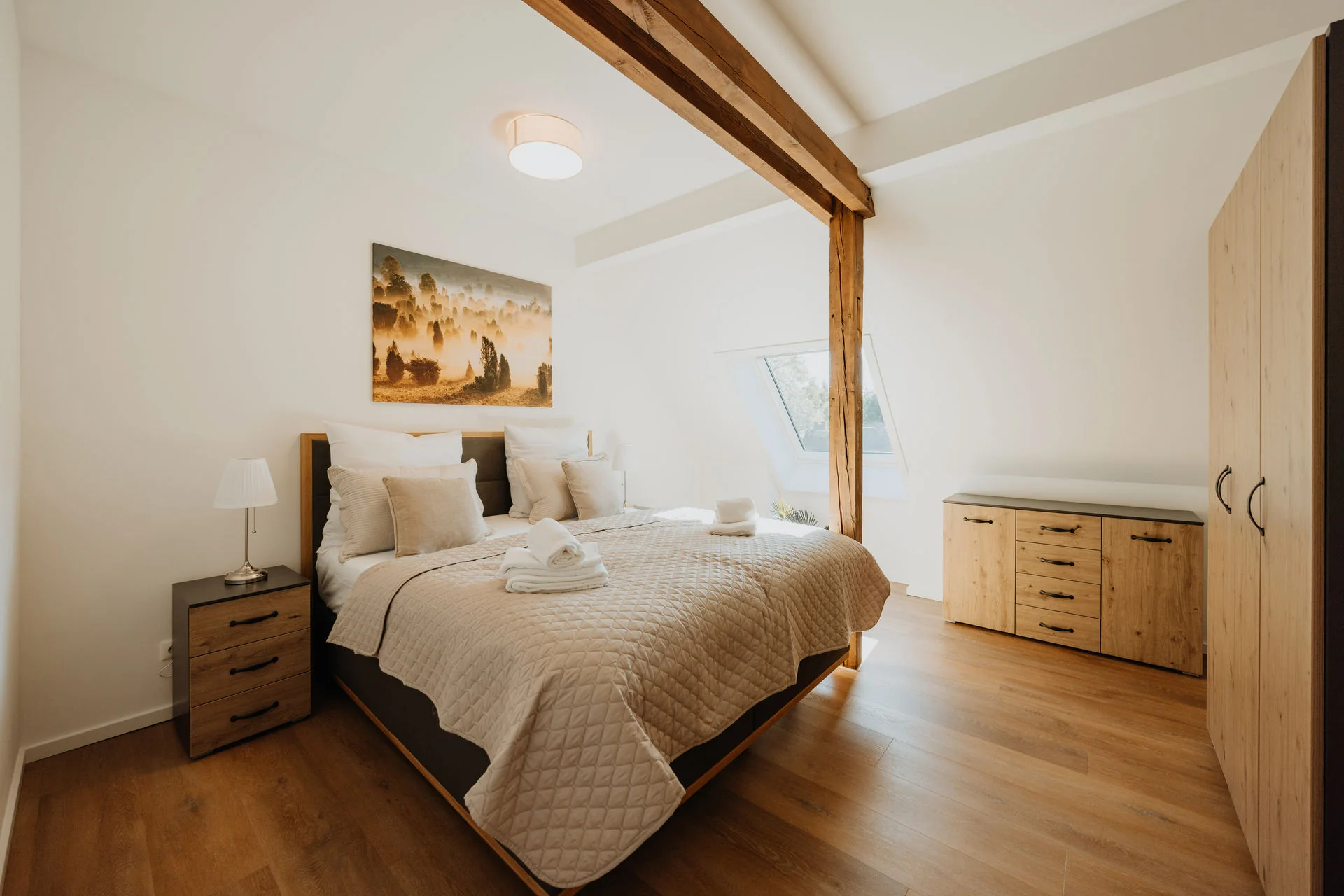 Koppelidyll: Schlafzimmer mit Doppelbett, Holzschrank und sichtbarem Holzbalken