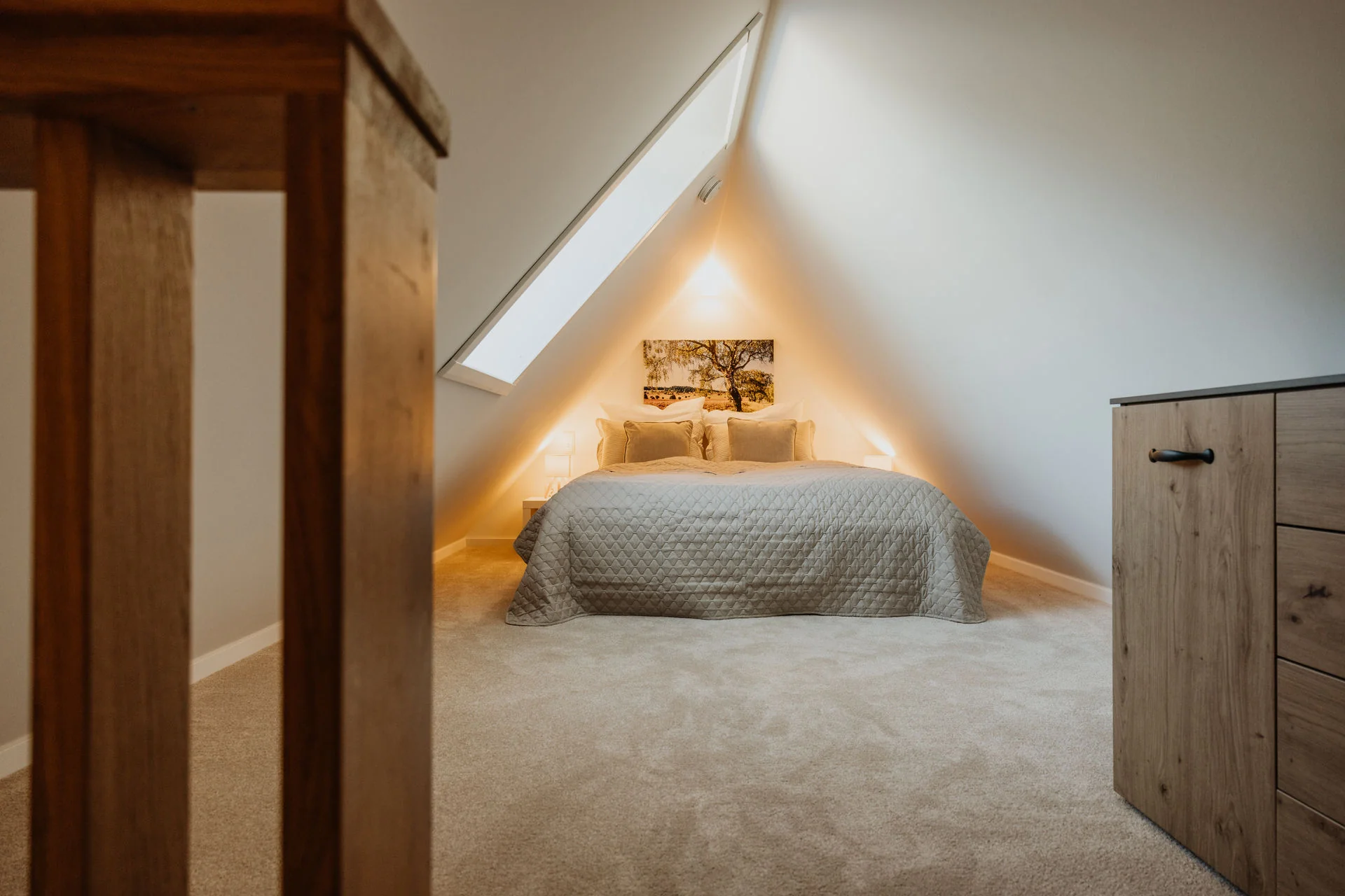 Koppelidyll: Schlafzimmer unter der Dachschräge mit Dachfenster und Kommode
