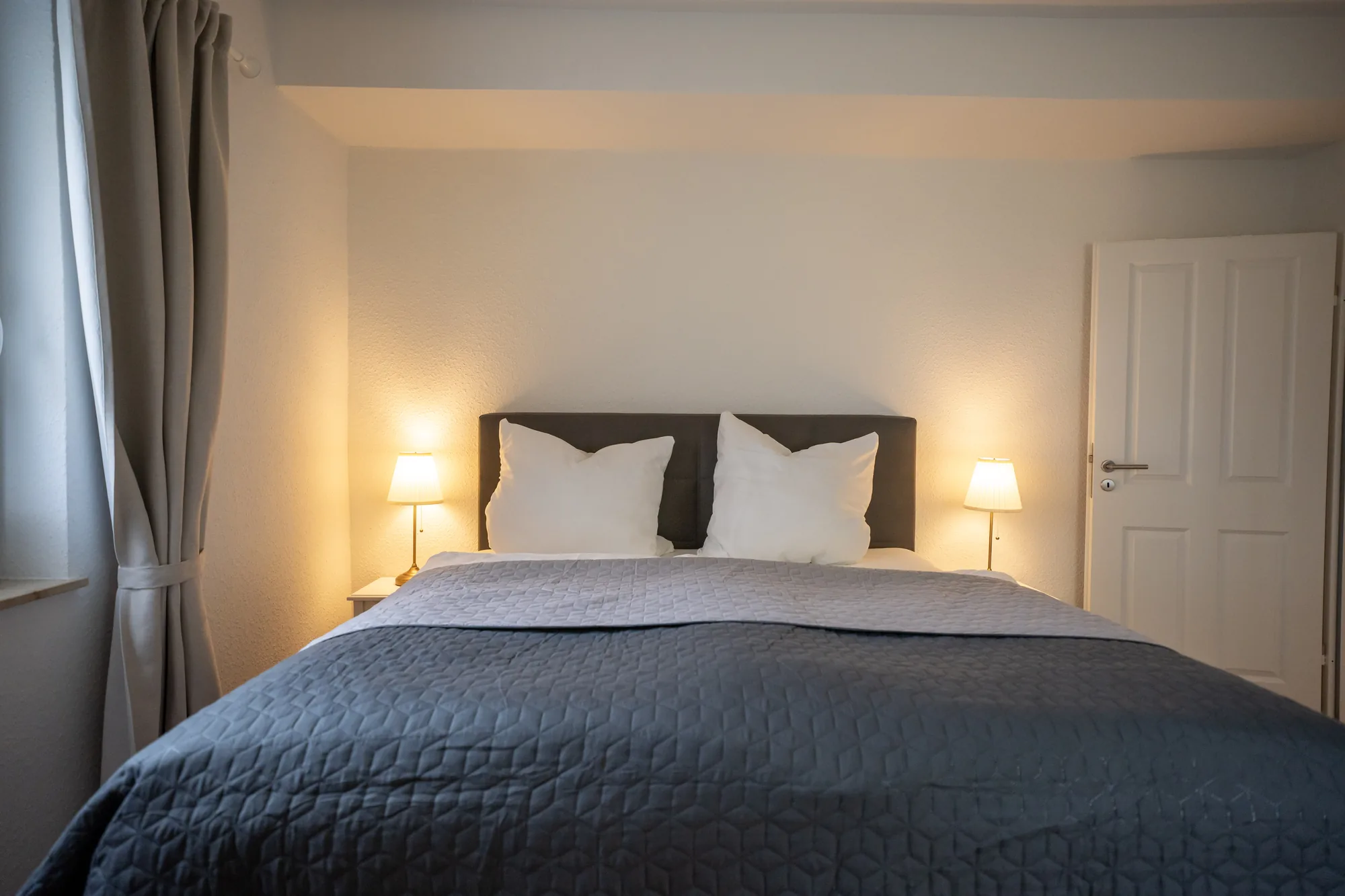 Reetdachblick: Schlafzimmer mit Doppelbett und zwei Nachttischleuchten